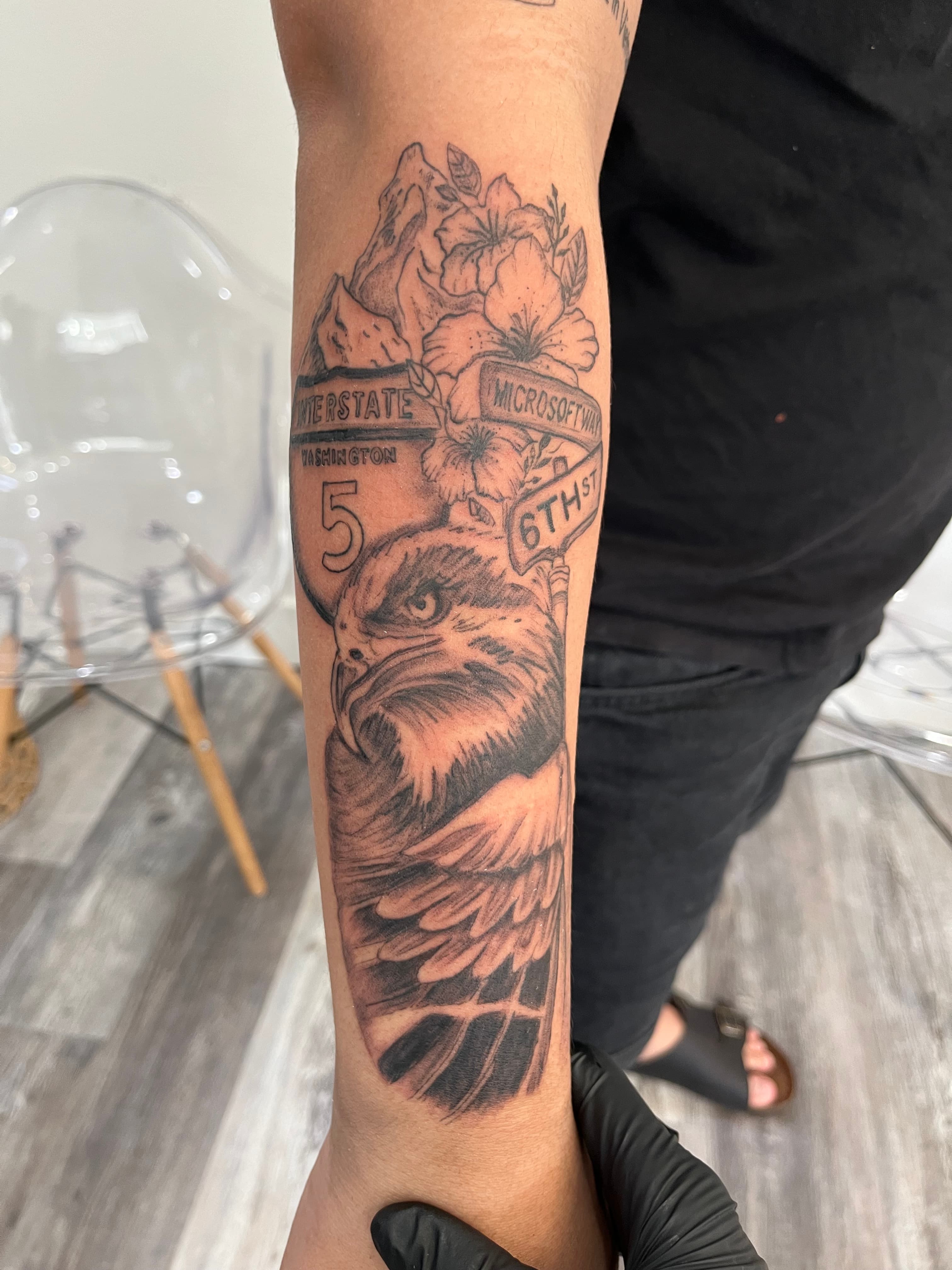 Black and grey eagle with florals illustrative forearm tattoo by Tony Luong Maple Valley WA